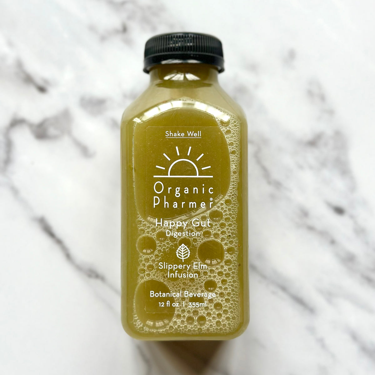 A bottle of Organic Phamer's Happy Gut, a functional botanical beverage with a greenish hue, labeled for digestive support.